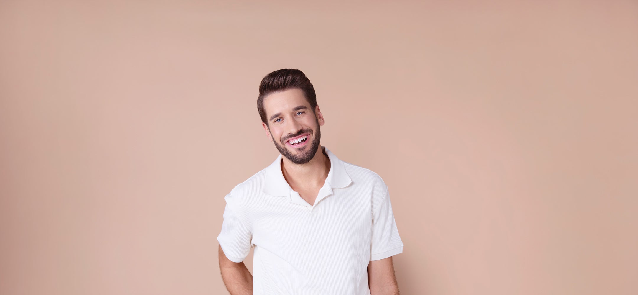 lachender-mann-mit-bart-vor-beigem-hintergrund