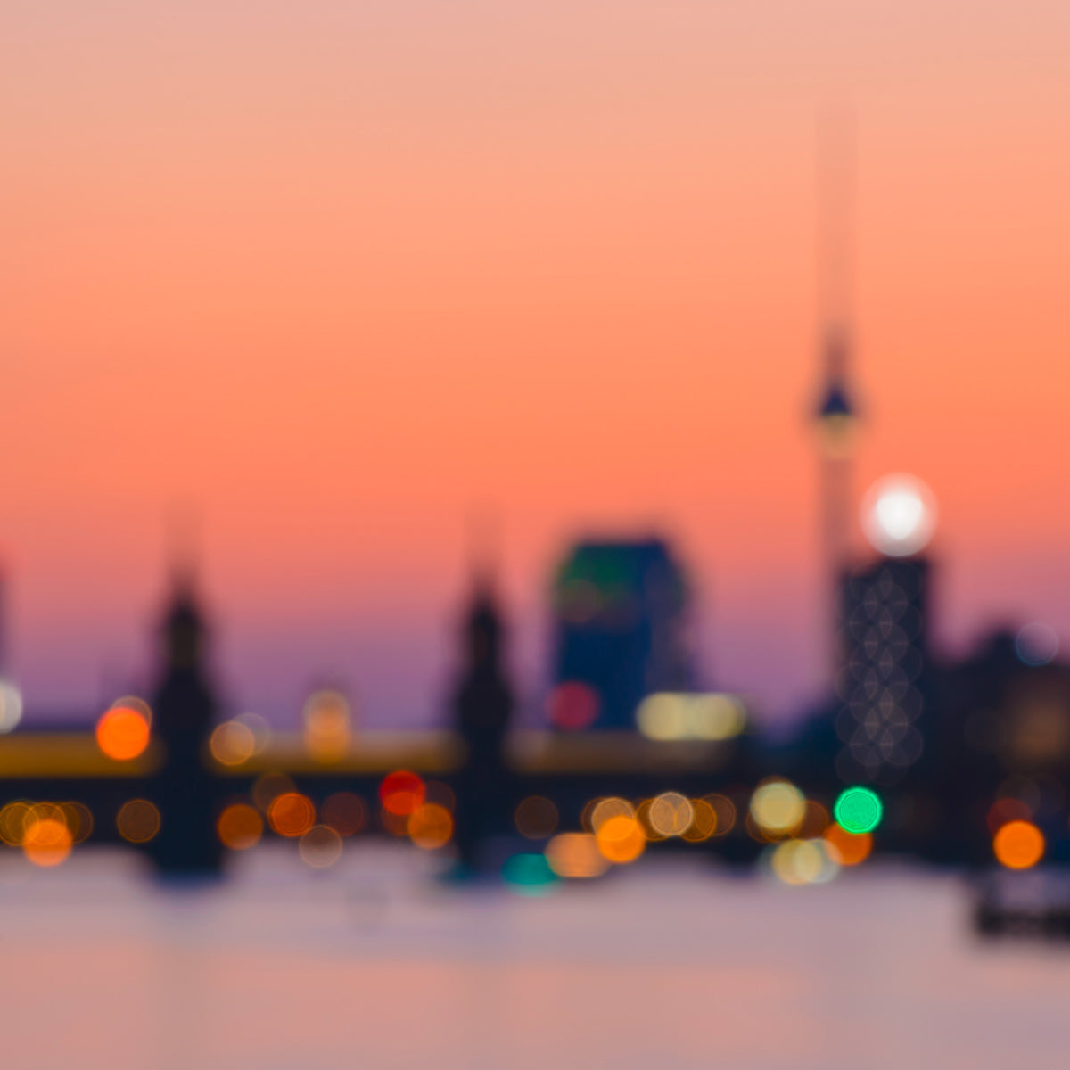 unscharfe-aufnahme-berliner-skyline-mit-fernsehturm-und-lichtern-bei-sonnenuntergang